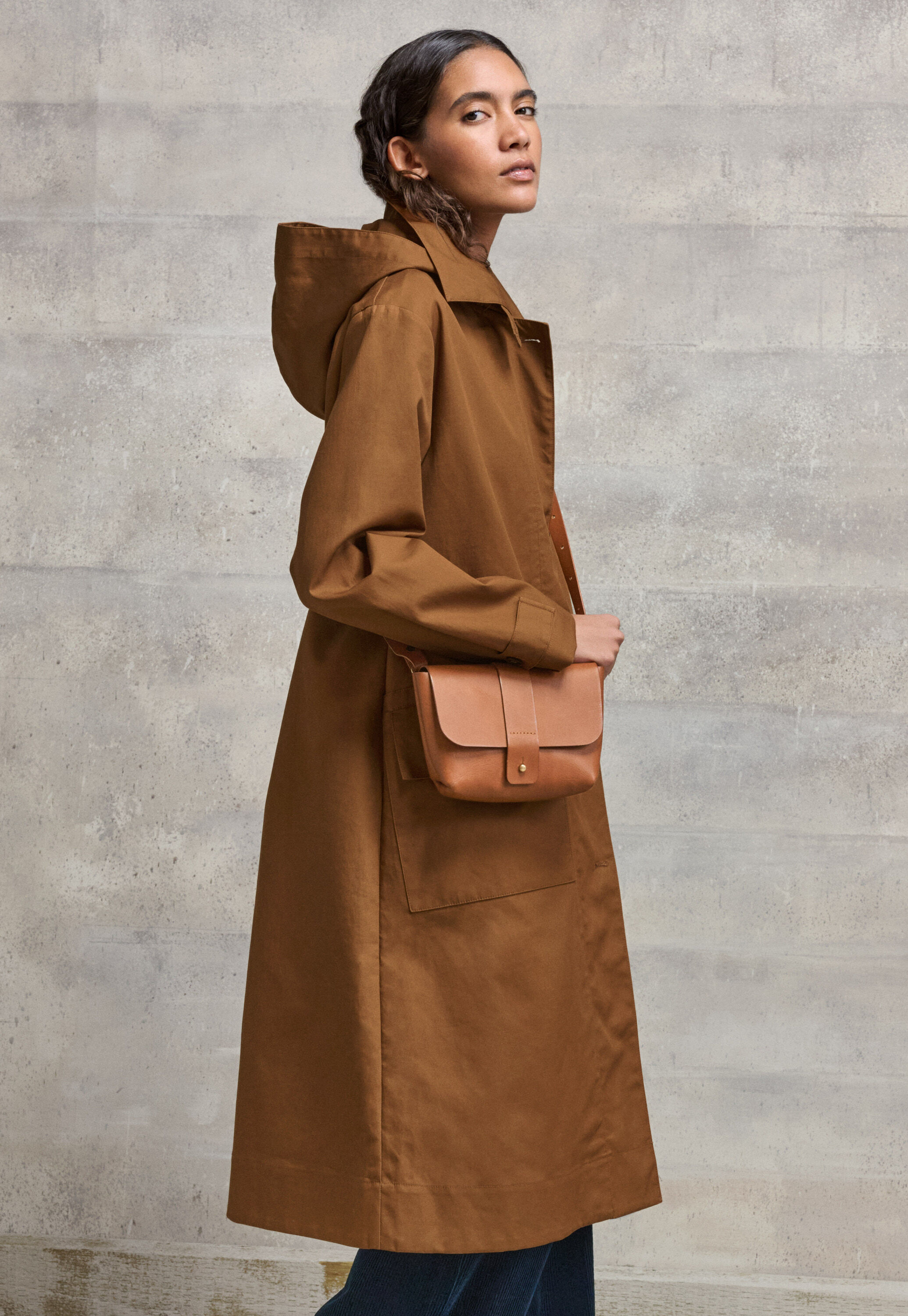 A contemporary trench coat in bonded, water-repellent cotton. There is a removable hood for when the sun comes out.